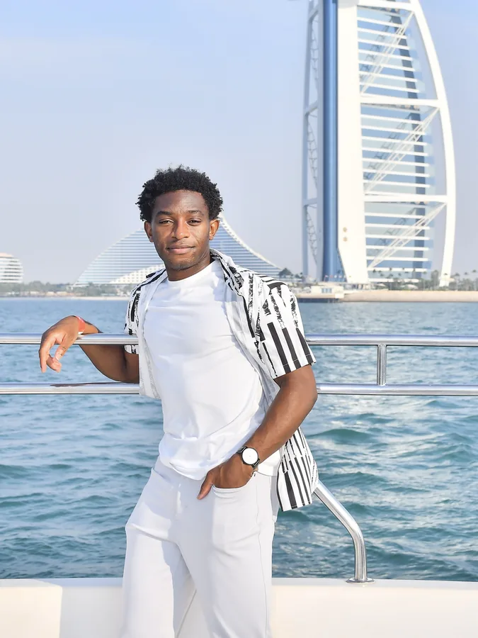 A traveler on a boat with the Burj Al Arab in the background.