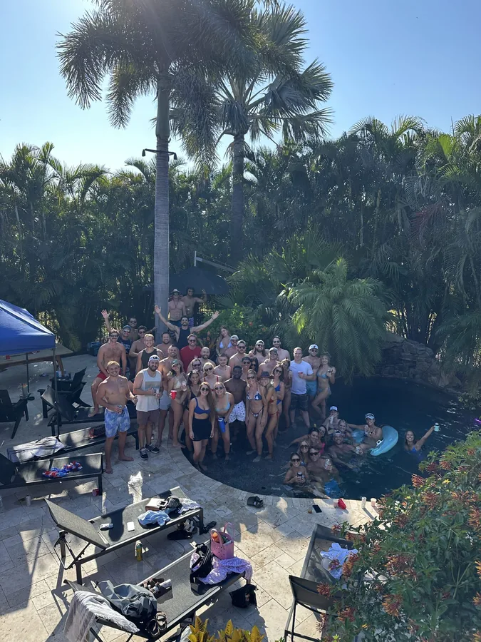 Friends gathering in a garden surrounded by palm trees.