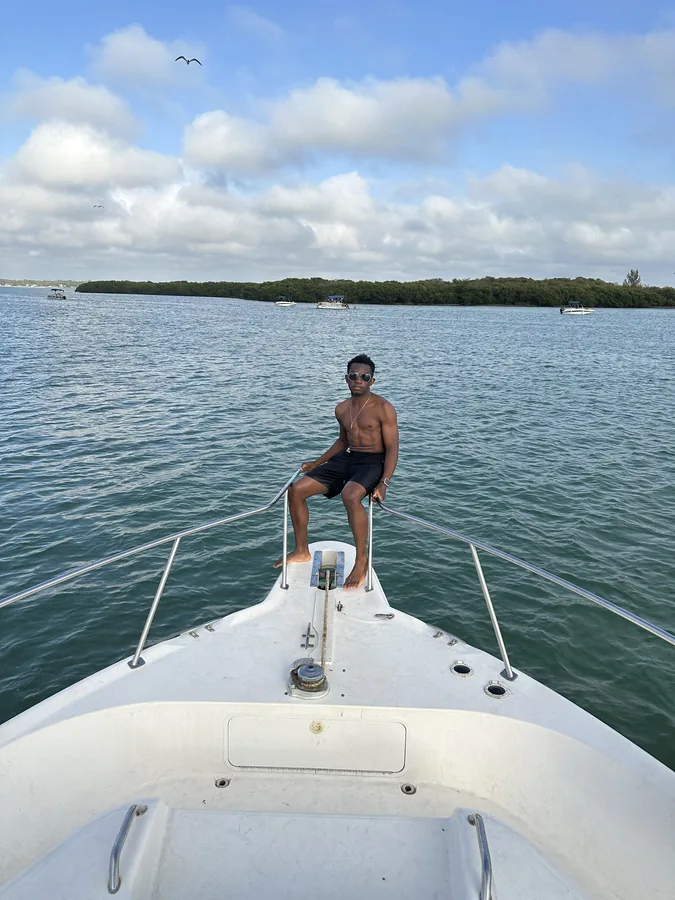 A traveler seated at the bow of a boat on open water.