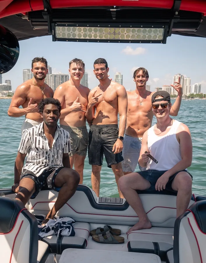 Friends on a boat with the waterfront skyline behind them.