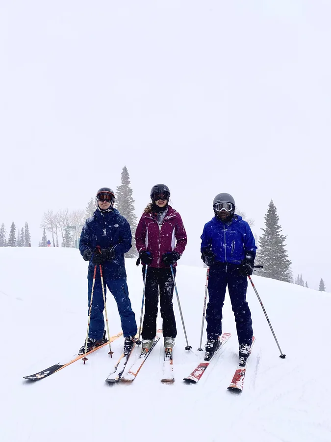Three skiers posing together on a snowy slope.